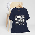 White hand-drawn typography saying Overthinking Mode with laptop and book doodles on a dark premium t-shirt.