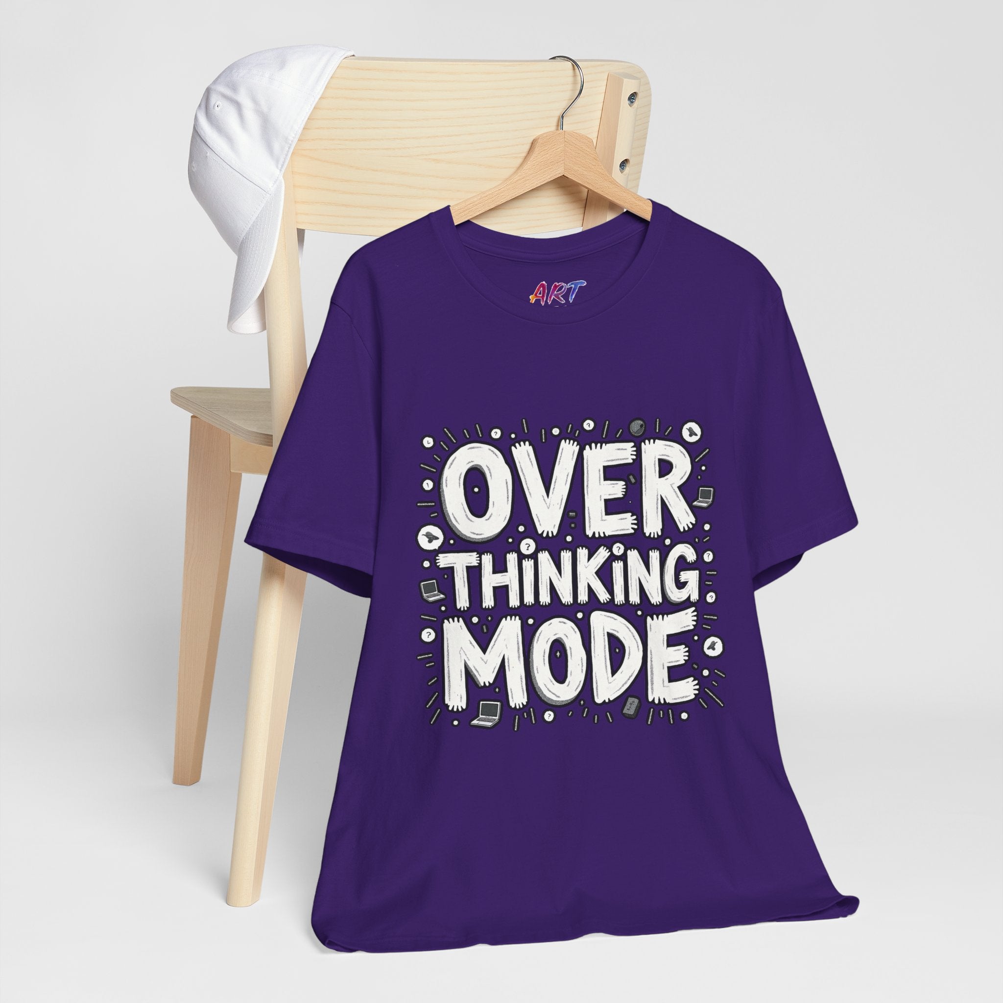 White hand-drawn typography saying Overthinking Mode with laptop and book doodles on a dark premium t-shirt.