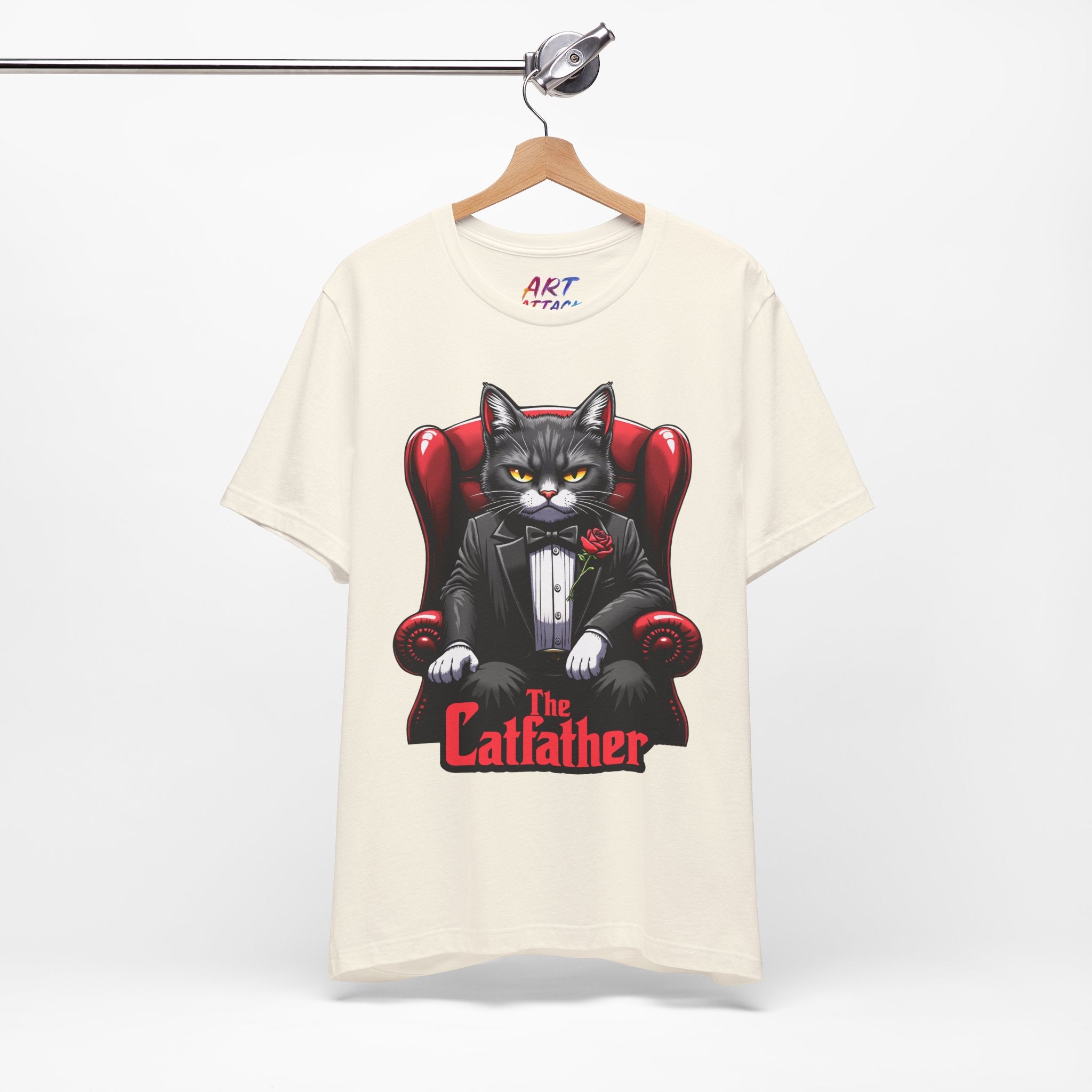 A serious grey cat dressed in a black tuxedo with a red rose on the lapel, sitting like a mafia boss in a red leather armchair with the text The Catfather below.