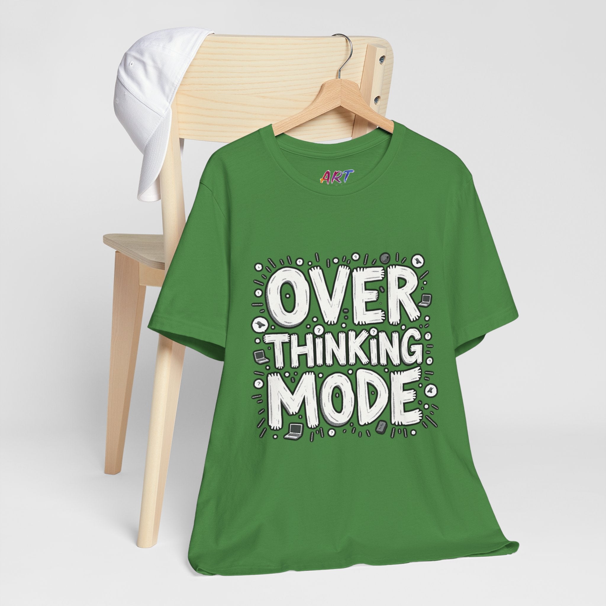 White hand-drawn typography saying Overthinking Mode with laptop and book doodles on a dark premium t-shirt.