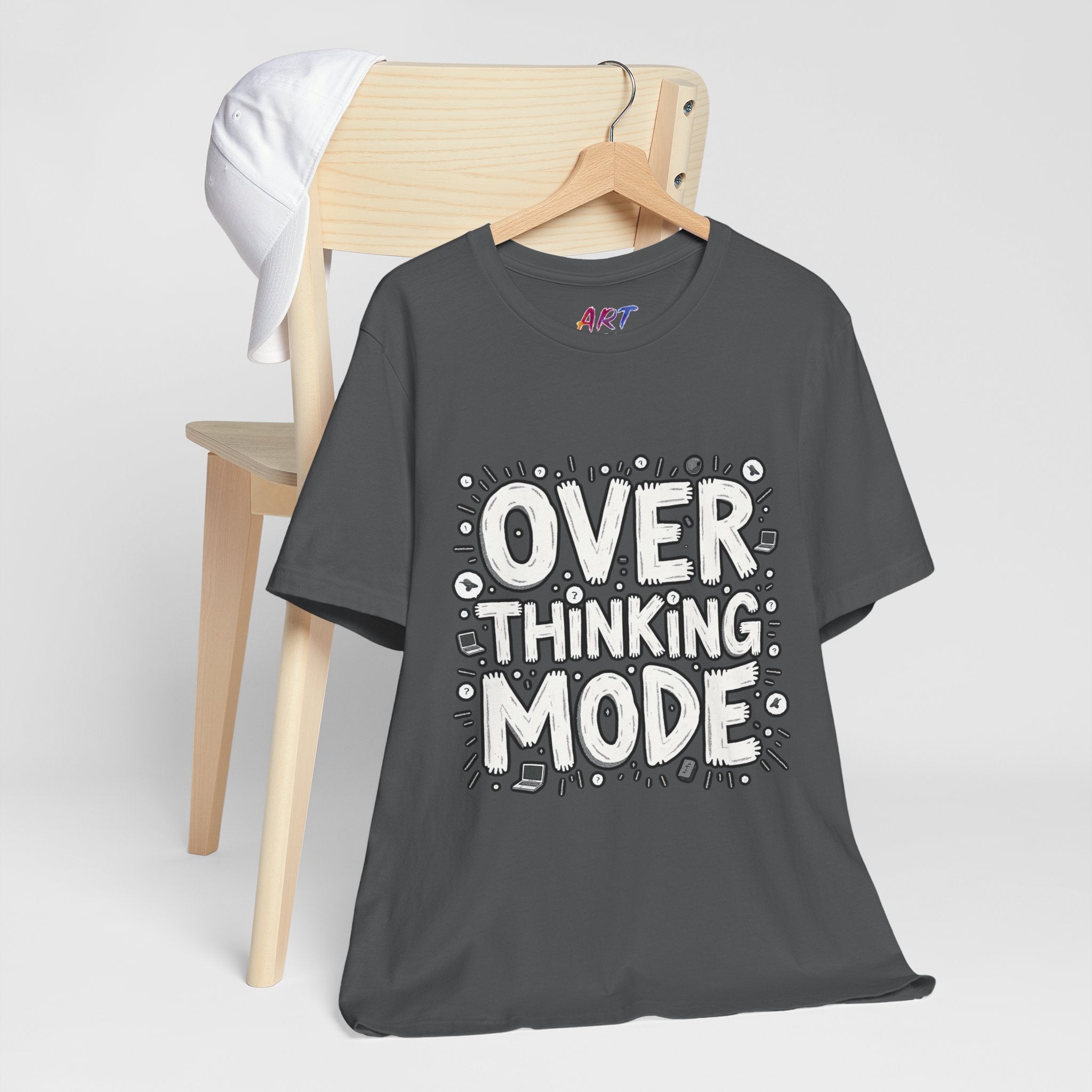 White hand-drawn typography saying Overthinking Mode with laptop and book doodles on a dark premium t-shirt.