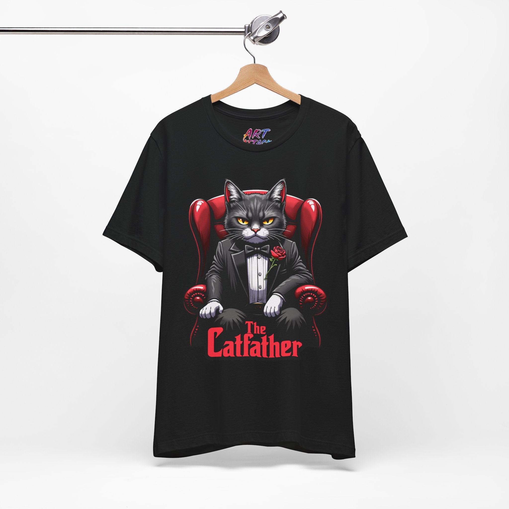 A serious grey cat dressed in a black tuxedo with a red rose on the lapel, sitting like a mafia boss in a red leather armchair with the text The Catfather below.