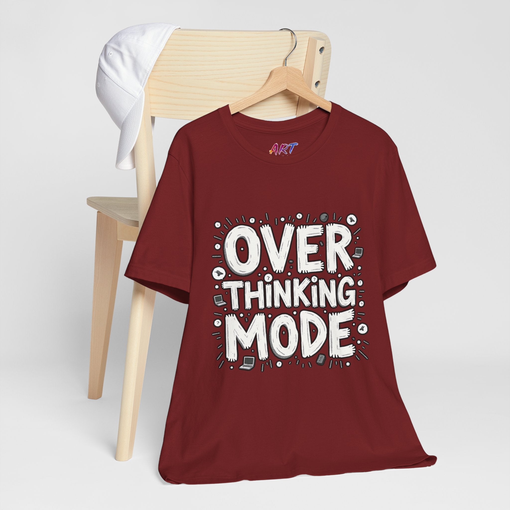 White hand-drawn typography saying Overthinking Mode with laptop and book doodles on a dark premium t-shirt.