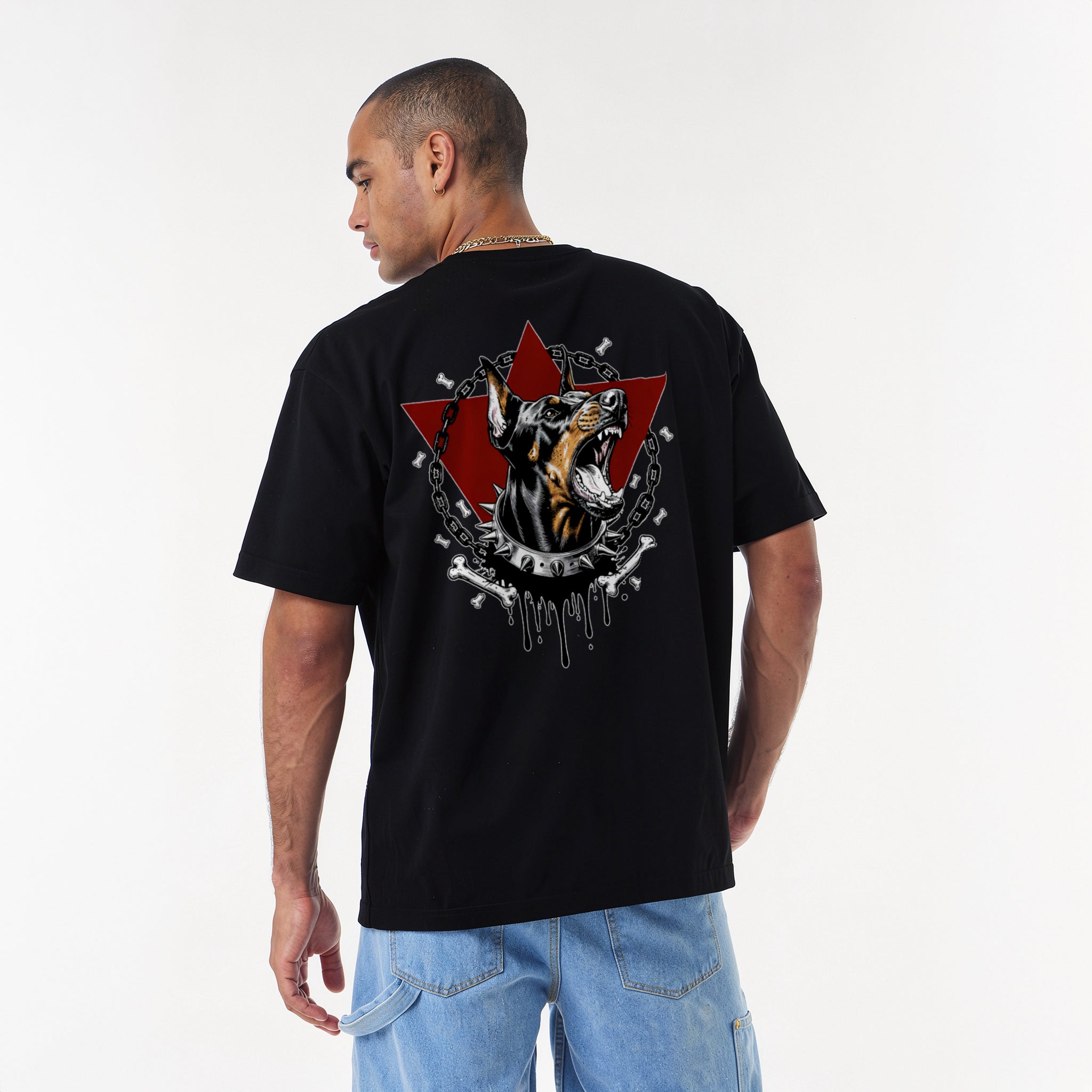 oversized streetwear t-shirt. Front shows the word UNTAMED in red dripping text. Back features an aggressive Doberman dog with a spiked collar, chains, bones, and a red triangle background.