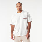 oversized streetwear t-shirt. Front shows the word UNTAMED in red dripping text. Back features an aggressive Doberman dog with a spiked collar, chains, bones, and a red triangle background.